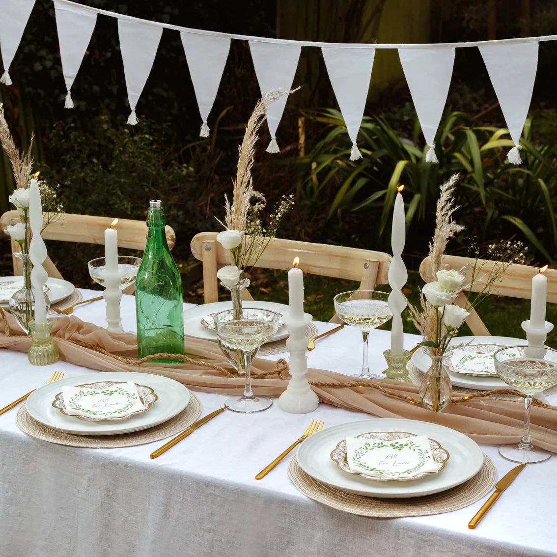 Outdoor table with lots of decorative pieces, candles and bunting