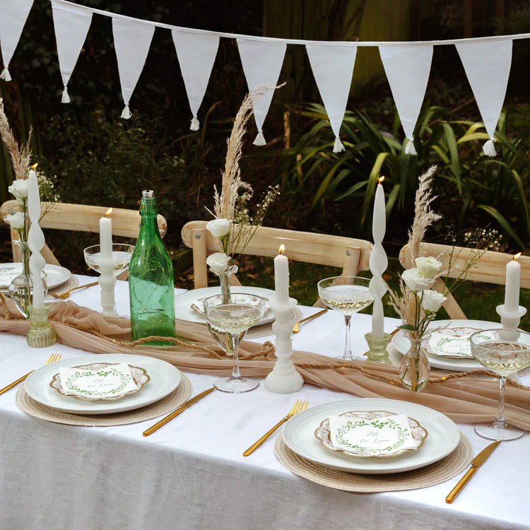 Outdoor table with lots of decorative pieces, candles and bunting