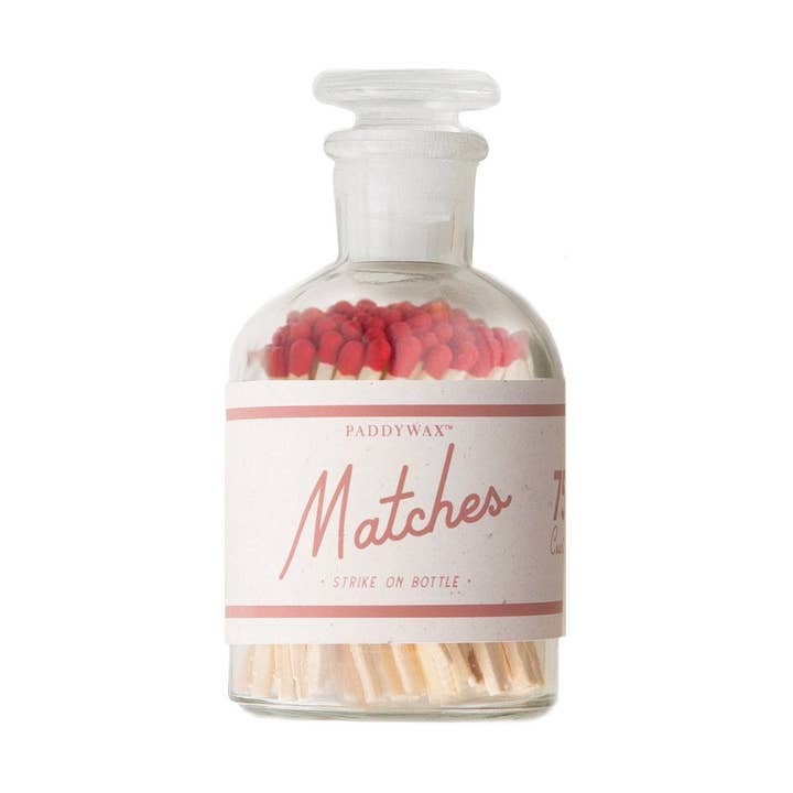 Glass bottle with matchsticks and red matches on a white background
