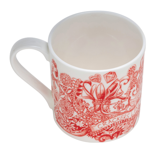 A white ceramic mug featuring a red toile-style pattern with illustrations of sweets, flowers, and the text 'CRACKERS LONDON' on a plain white background.