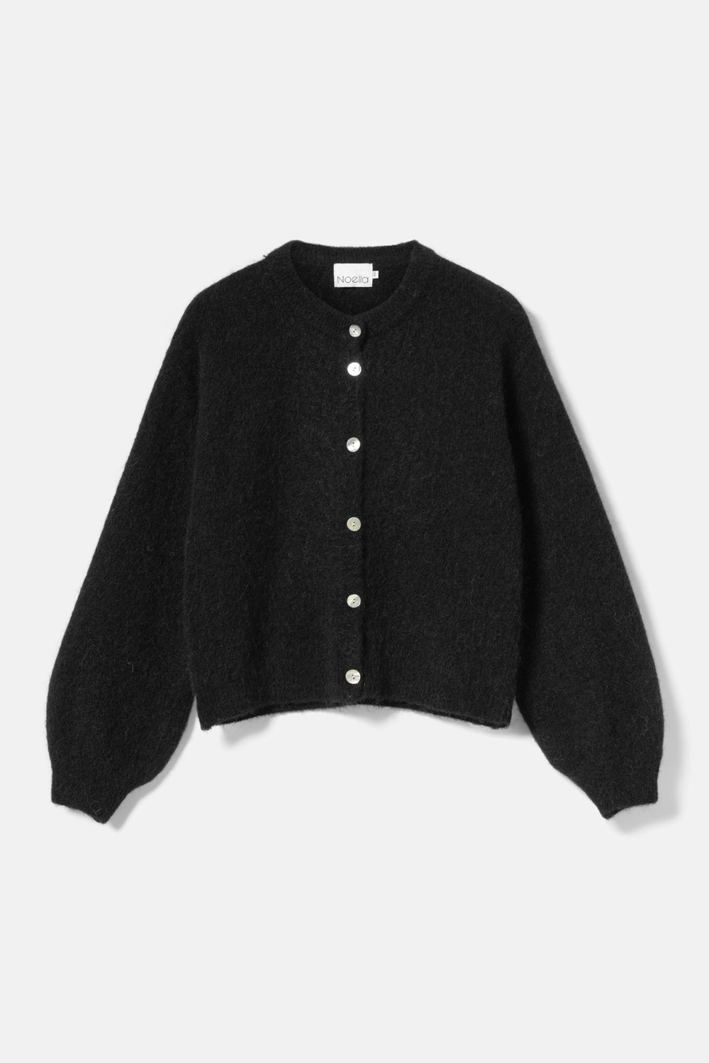 Noella Kae Knit Cardigan in Black. Black cardigan with button details on a light gray background