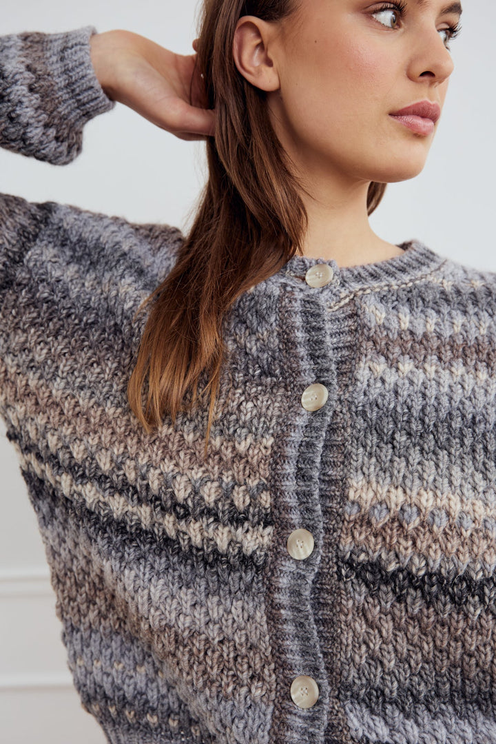 Noella Kae Knit Cardigan in Light Grey Mix. Woman wearing a patterned cardigan with a neutral background
