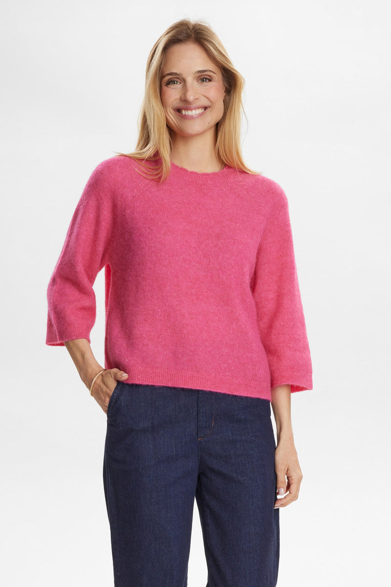 Numph Nurietta Selma Pullover in Fandango Pink Woman wearing a pink sweater and blue pants on a white background
