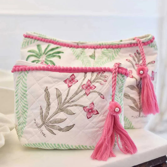 quilted washbag with pale green leaves framing palm trees and exotic flowers against a white background