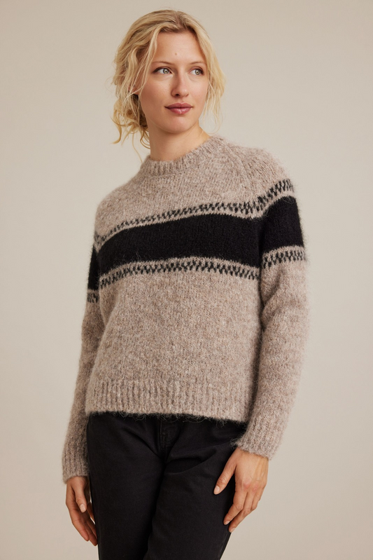 Woman wearing a striped sweater against a plain background