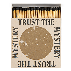 Matches with 'Trust the Mystery' text on a cardboard box