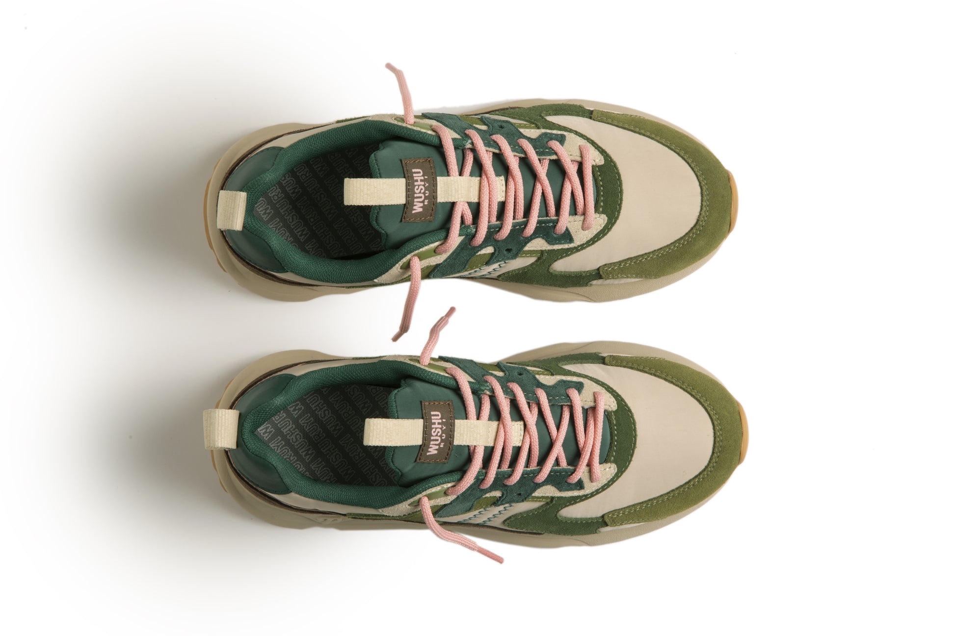 Green and beige sneakers with pink laces on a white background