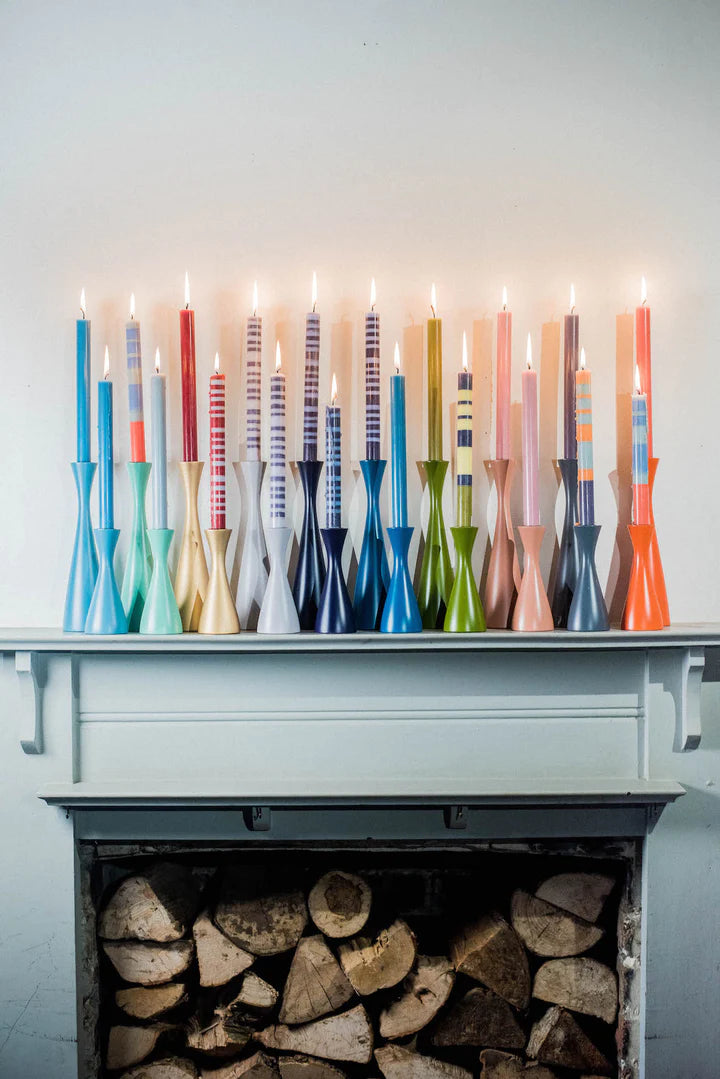 Variety of different coloured candles and candle holders