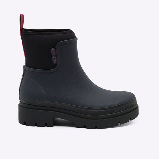A single black rubber rain boot with a black elastic side panel and a red pull tab, shown from a side profile on a light gray background.