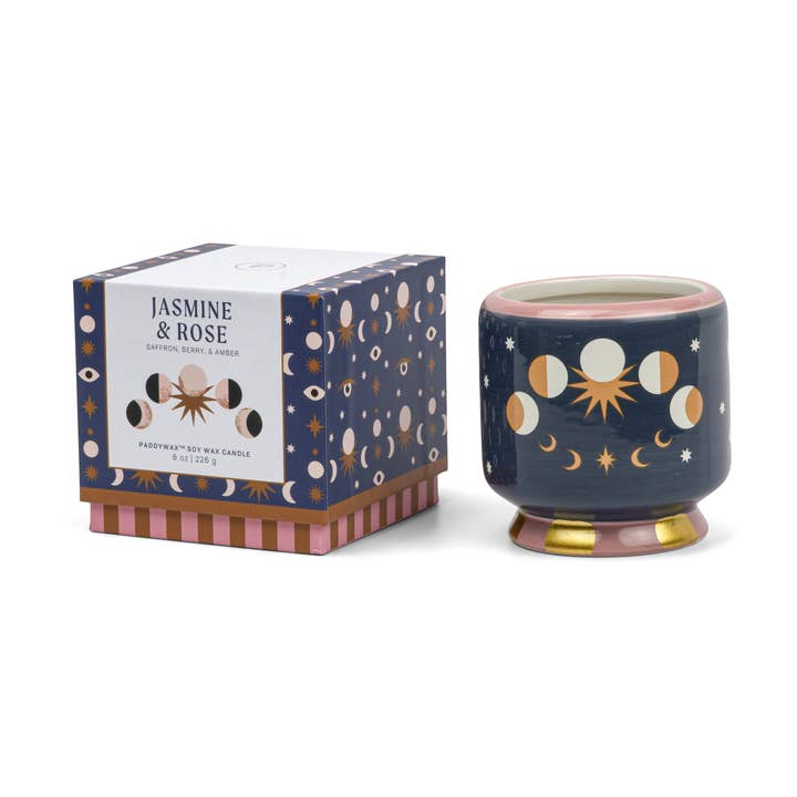 Decorative candle with celestial design and matching box on a white background