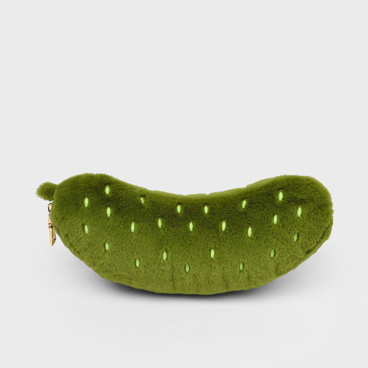 Plush Pickle Zip Pouch - a green plush pickle-shaped pouch with embroidered details and a small gold zipper pull, shown on a light grey background.