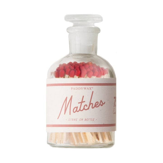 Glass bottle with matchsticks and red matches on a white background
