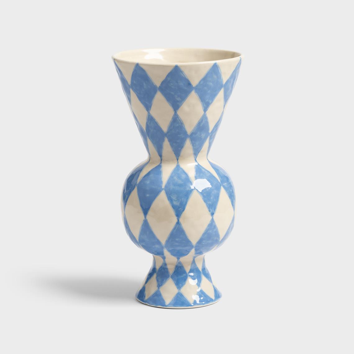 Ceramic vase with blue and white diamond pattern on a light gray background