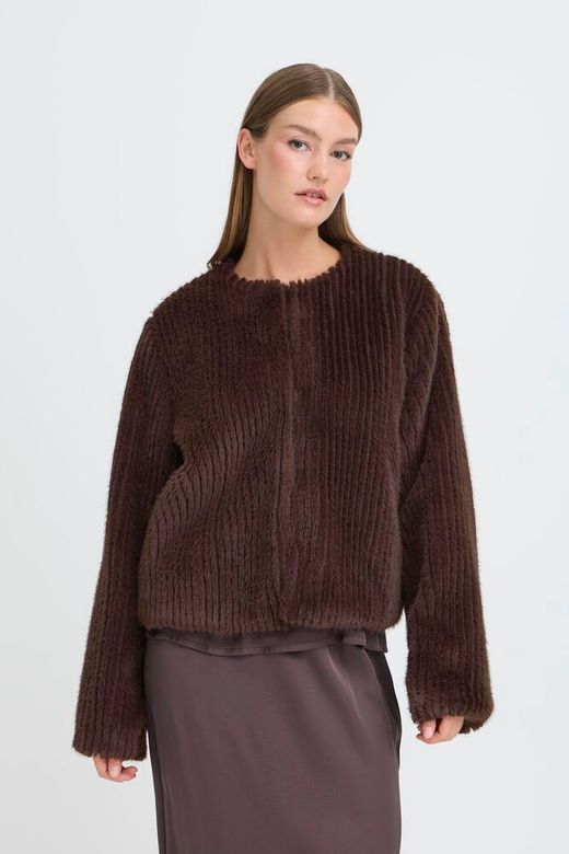 Woman wearing a brown ribbed sweater on a white background