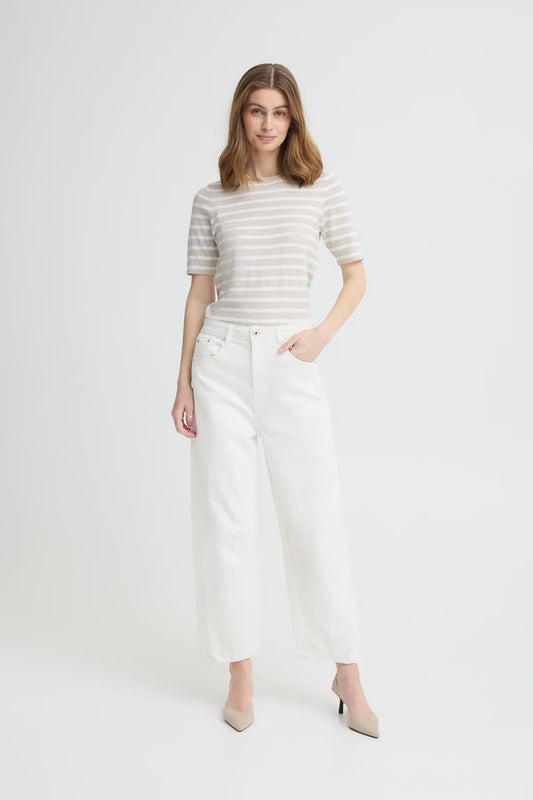 Woman wearing a striped shirt and white pants on a white background
