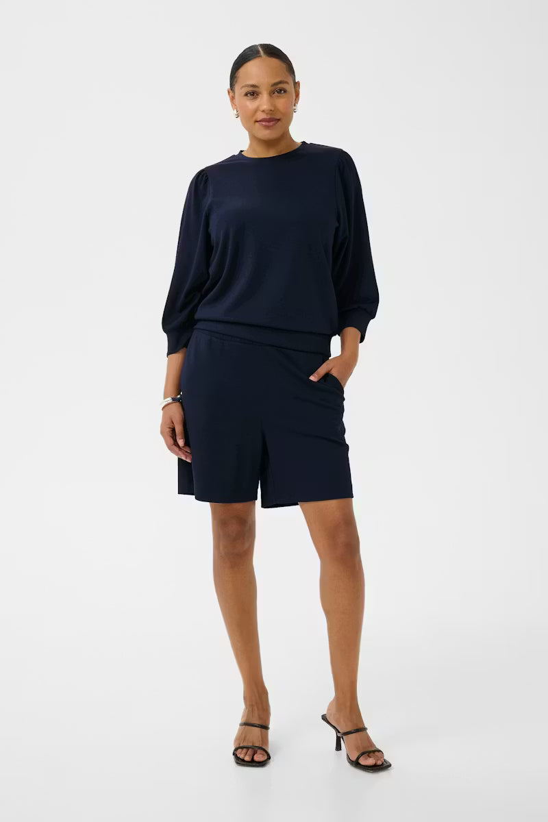 Woman wearing a navy blue outfit on a white background