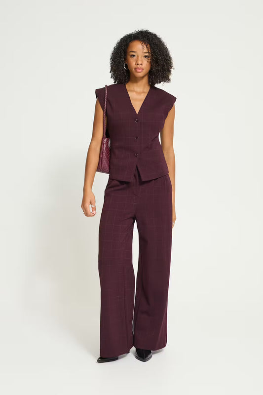 Ichi Kate Sparkelly Waistcoat in Fudge - A woman modelling a matching sleeveless button-front vest and wide-leg trousers set in a deep plum or burgundy tone, photographed against a clean light grey studio background.
