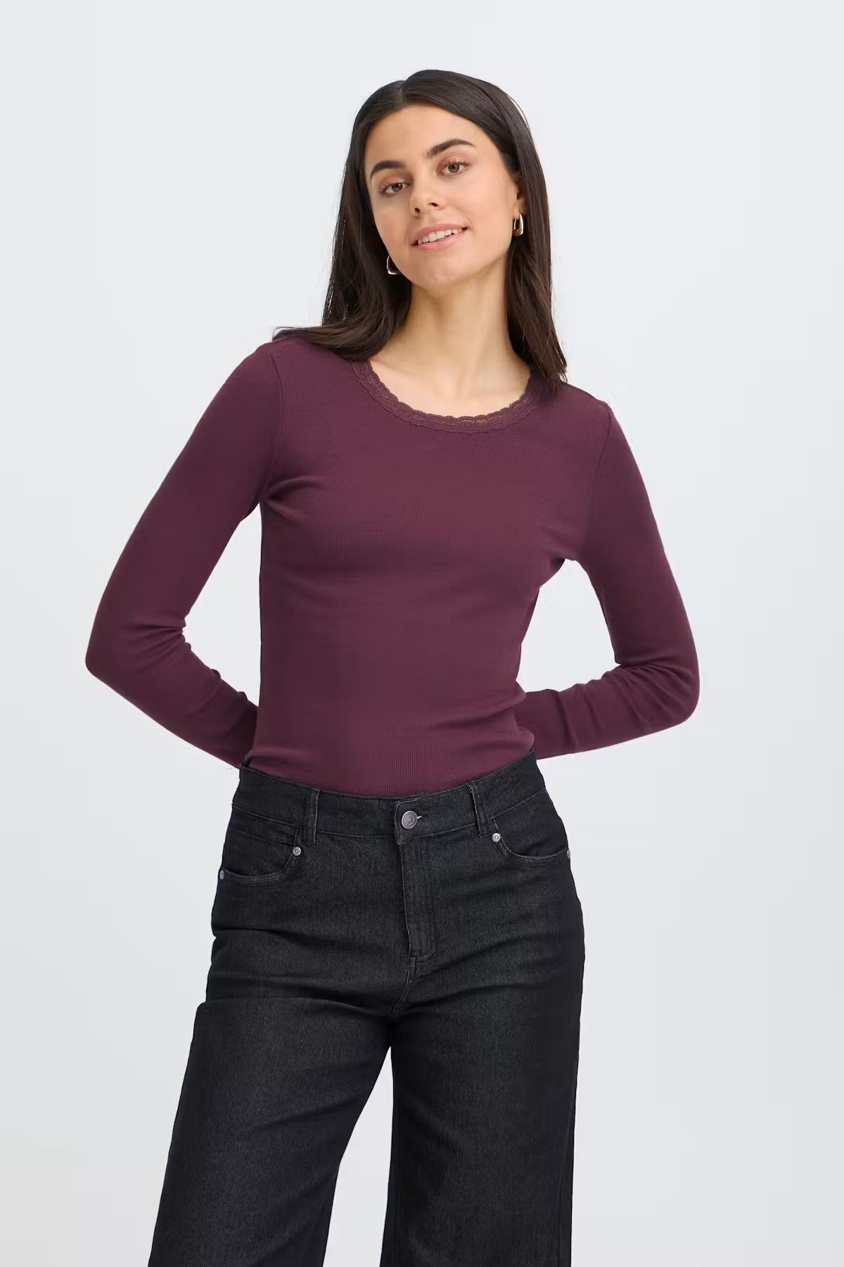 Fransa Hizamond Tee in Port Royal - A woman modeling a long-sleeve crewneck top in a deep plum purple color, paired with dark wash jeans, against a plain light gray background.
