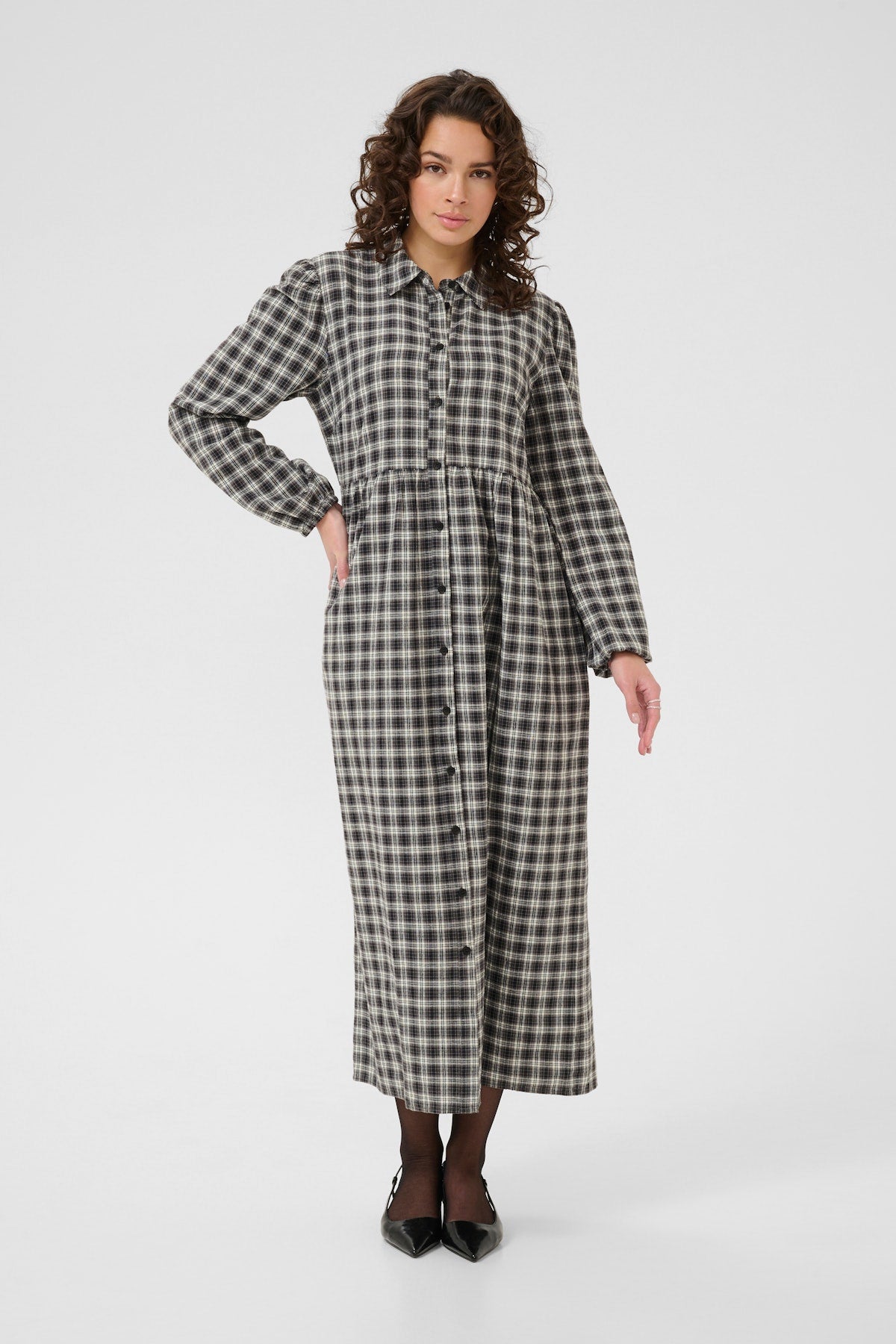Woman wearing a black and white checkered dress on a white background