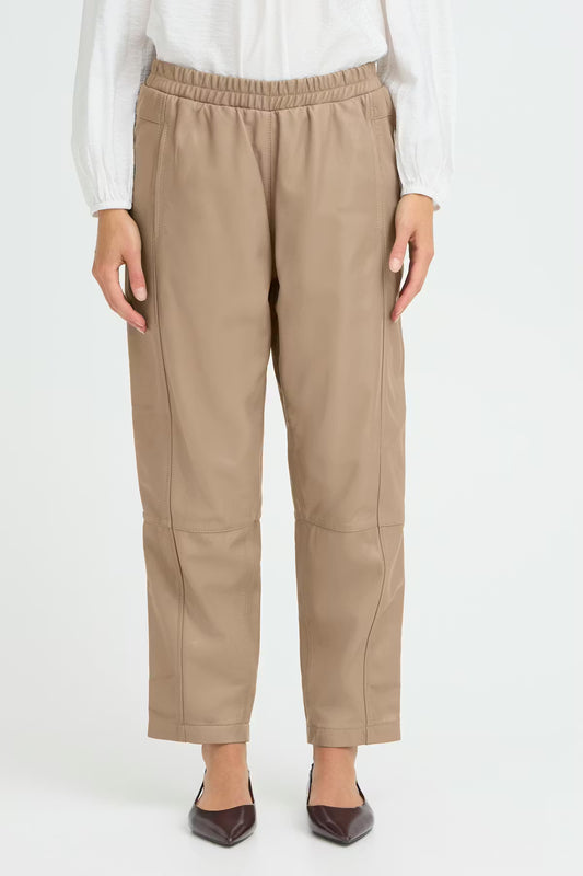 Beige pants worn by a person on a white background