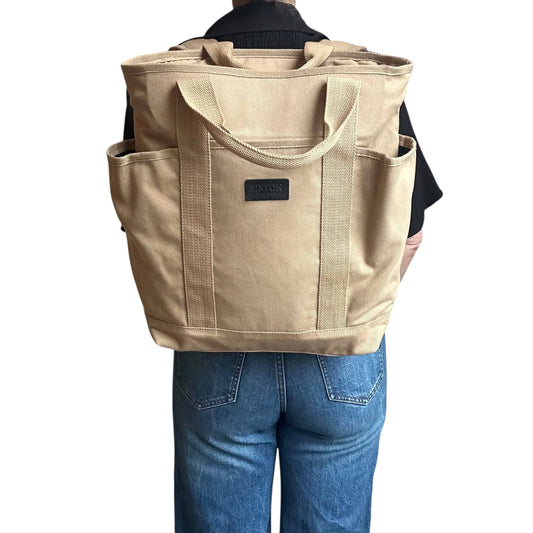 Sand Backpack on a person's back wearing jeans