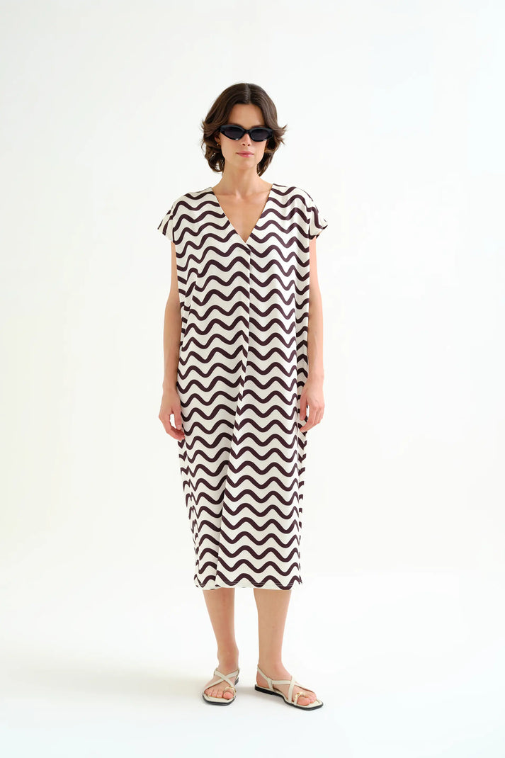 Woman wearing a black and white zigzag dress on a white background