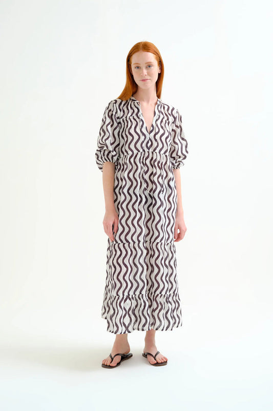 Woman wearing a black and white patterned dress on a white background