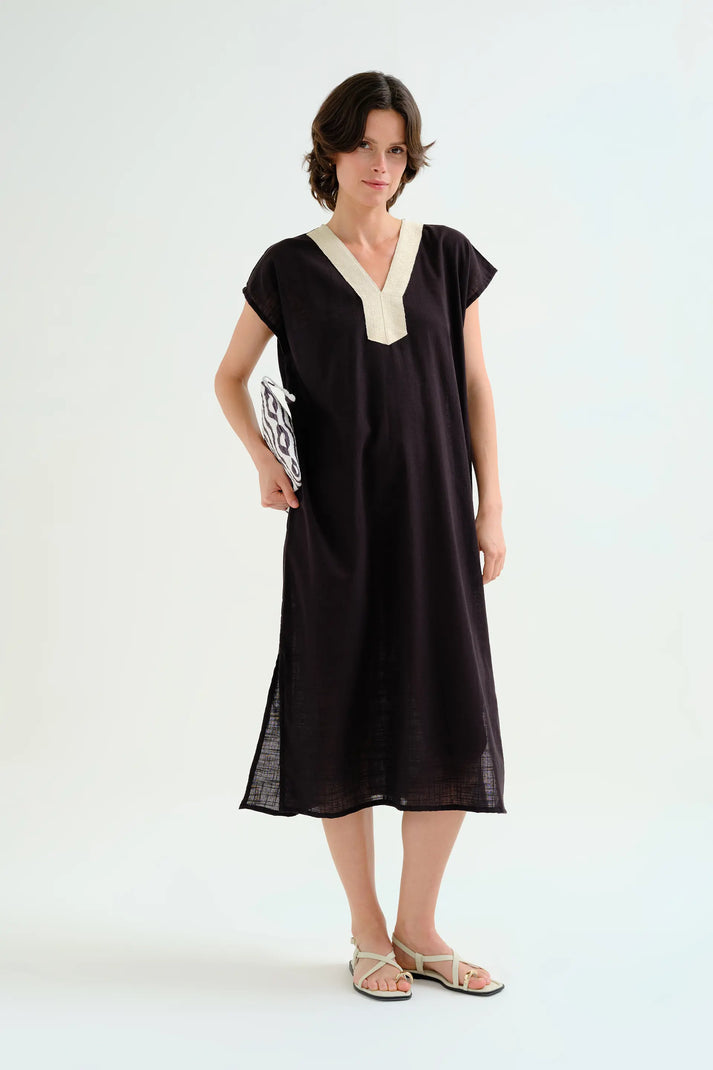 Woman wearing a black dress with a white collar on a white background