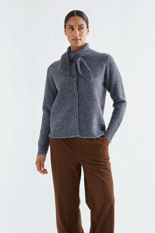 Compania Fantastica Blue and Brown Striped Knit Cardigan - A model wearing a textured blue-grey knit button-up cardigan with a high folded collar and bow detail, paired with brown corduroy pants, against a plain light grey background.