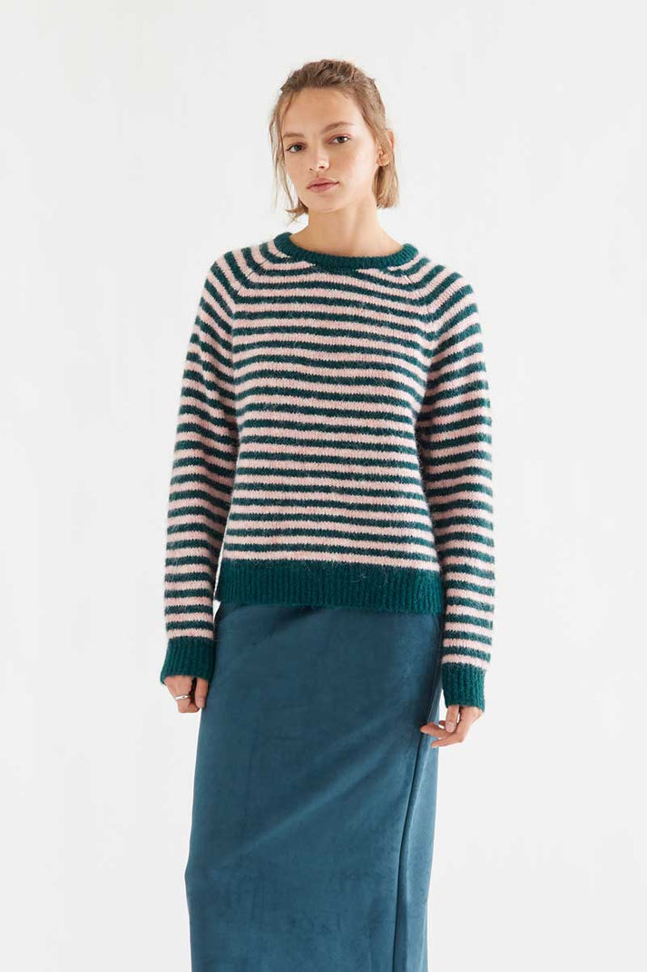 Compania Fantastica Dark Green and Pink Striped Knit Sweater - a woman modelling a fuzzy knit sweater with horizontal stripes in teal green and cream, paired with a teal green skirt, against a plain white studio background.