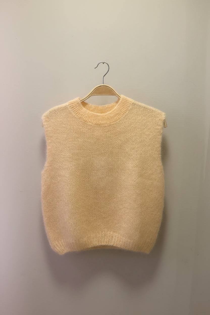 Peach sweater against a plain background