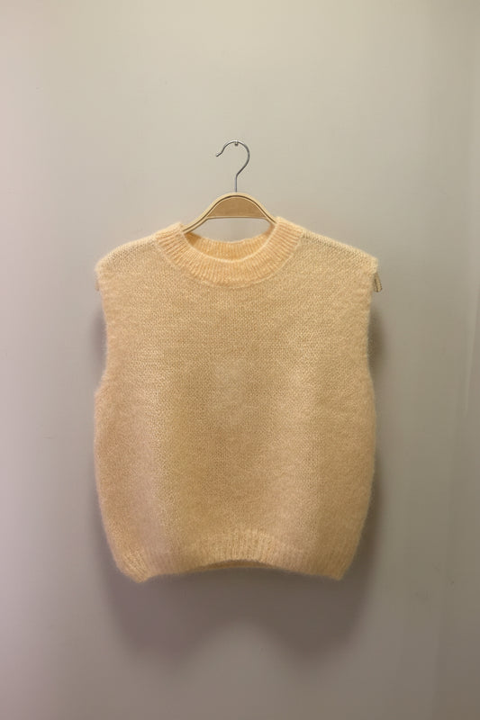 Peach sweater against a plain background