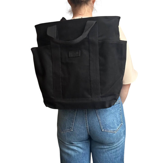 Person wearing a black tote bag on a white background