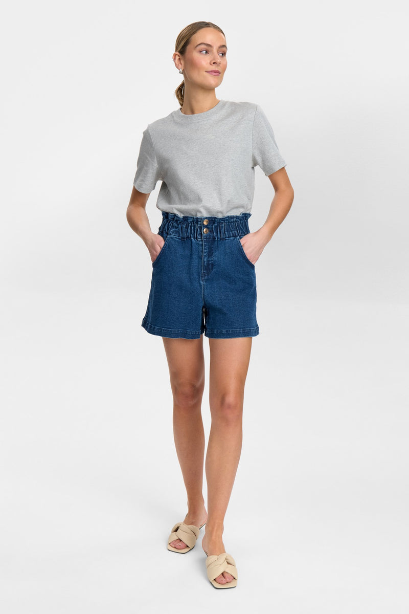 Woman wearing a gray t-shirt and blue denim shorts on a white background