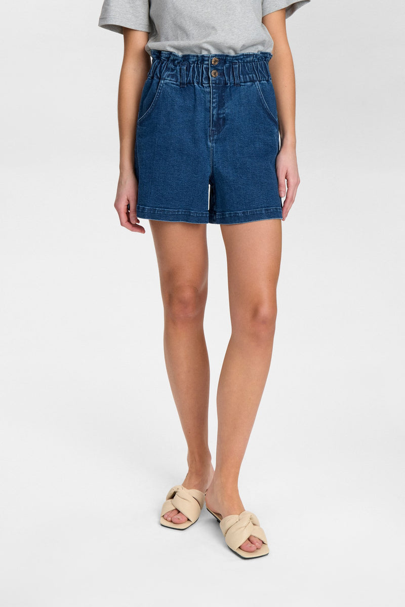 Person wearing blue denim shorts on a white background