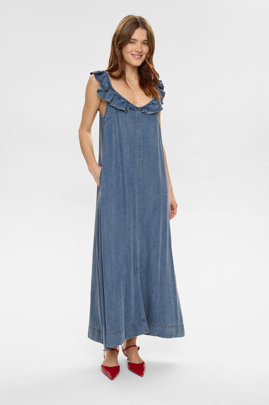 Woman wearing a blue dress with ruffled straps on a white background