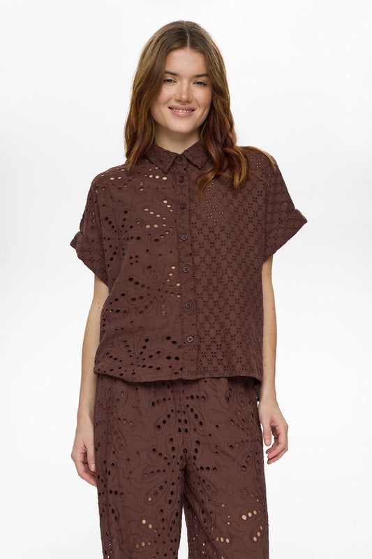 Woman wearing a brown lace outfit on a white background
