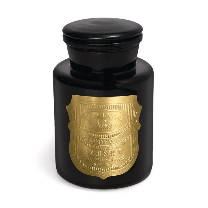 Black candle jar with gold label on a white background