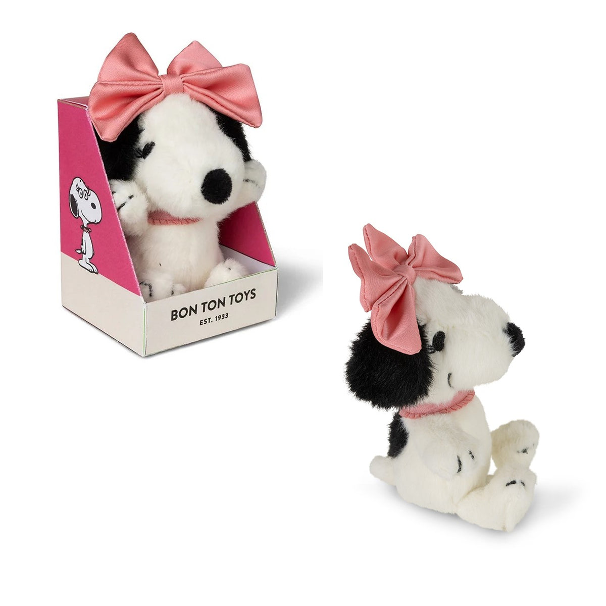 A plush Snoopy dog toy with a black-and-white body, pink bow, and pink collar, shown both inside its pink retail box and seated outside the box on a white background. The box reads 'BON TON TOYS EST.
