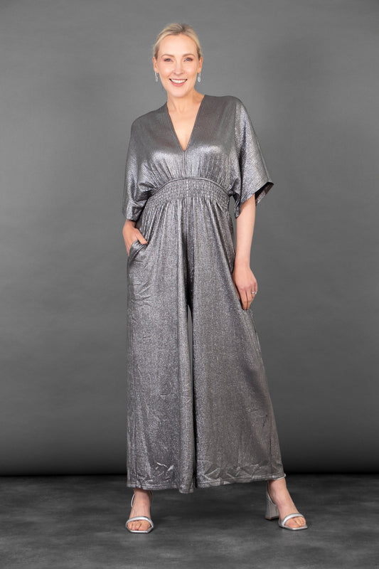Woman wearing a silver jumpsuit against a gray background