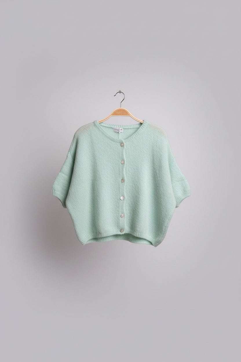 Green baby sweater on a hanger.