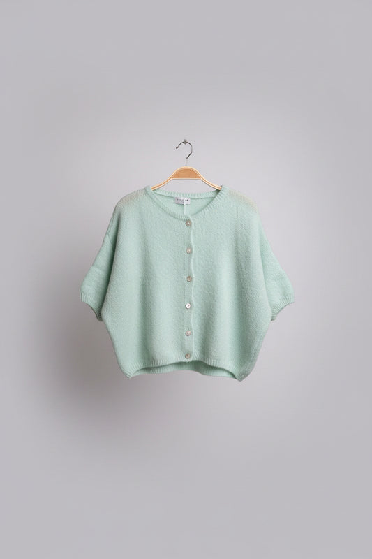 Green baby sweater on a hanger.