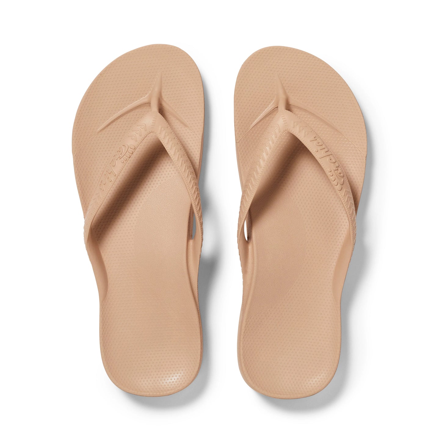 Pair of beige flip-flops on a white background