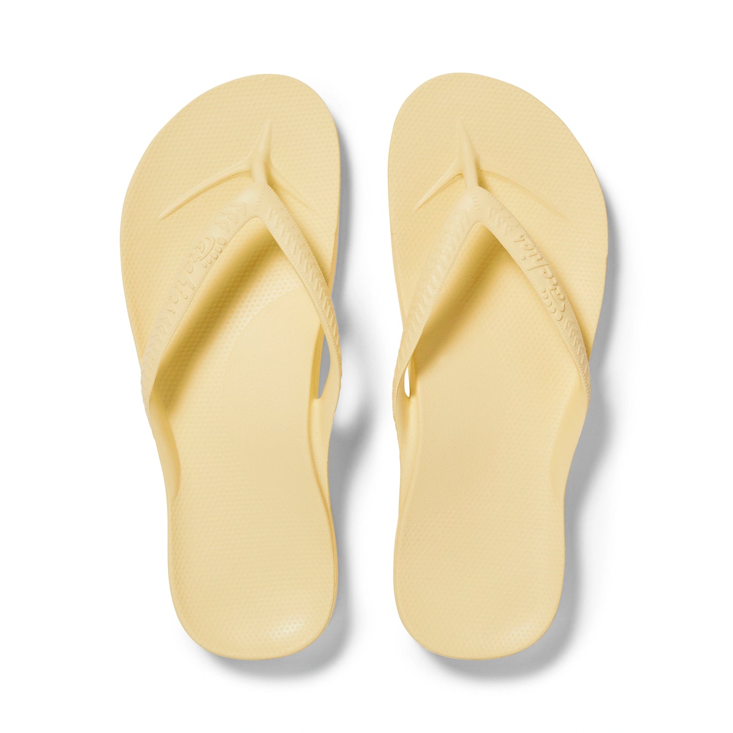 Pair of light yellow flip-flops on a white background