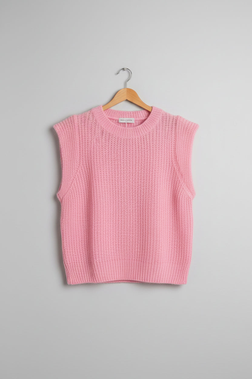 Pink knitted tank top on a hanger on a white background