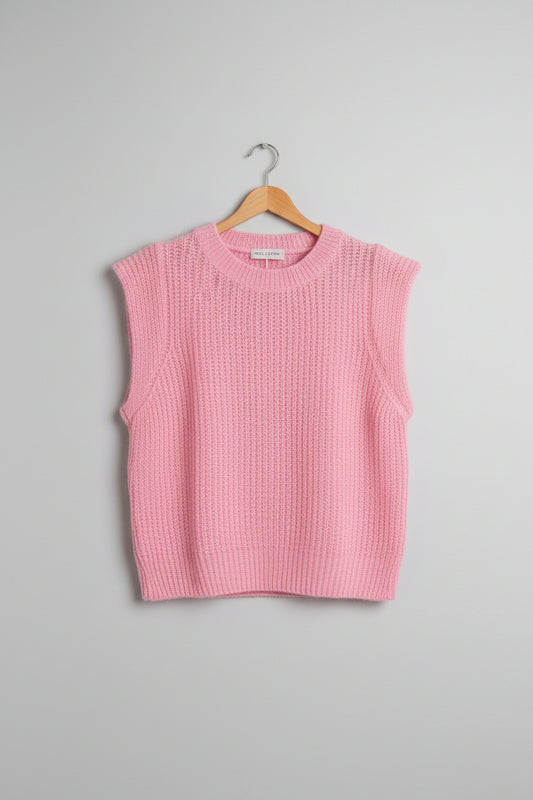 Pink knitted tank top on a hanger on a white background