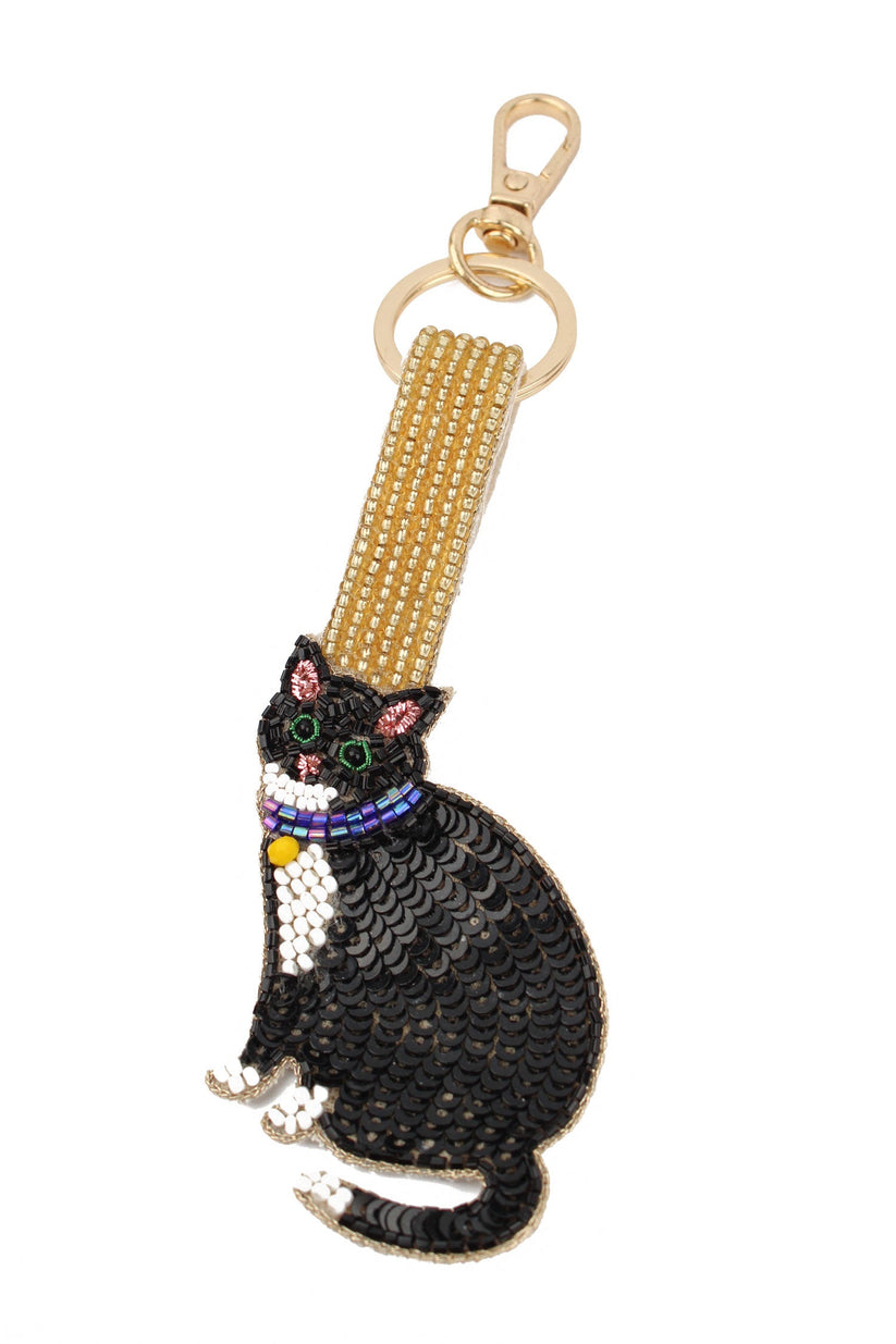 Black cat-shaped keychain with gold strap on a white background