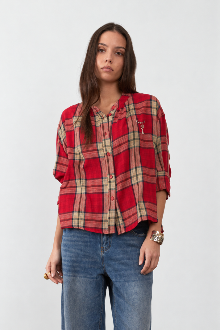 Orfeo Simone Blouse in Red checks - A woman modeling a red and beige plaid button-up shirt with blue jeans against a plain light grey background.