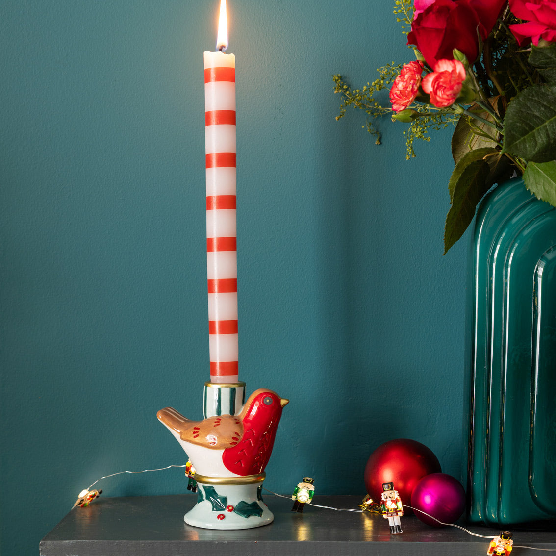 Hand-Painted Robin Candle Holder - Decorative candle holder with a striped candle, bird design, and Christmas ornaments on a teal background.