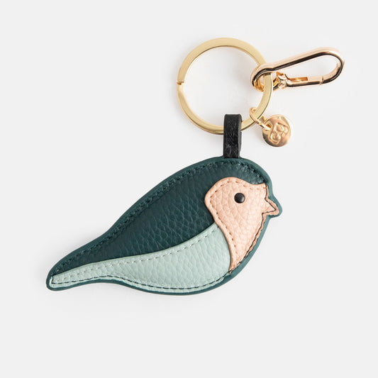 Caroline Gardner Green/Blue Bird Bag Charm. Bird-shaped keychain with gold ring on a white background